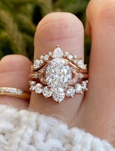 a close up of a person's hand holding a diamond ring