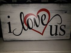 a wooden sign with the words i love us painted on it