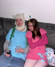 two people sitting on a couch wearing costumes