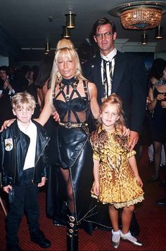 the family is posing for a photo in their black and gold outfits at an event