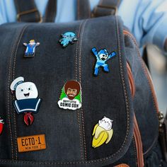 the back of a backpack with many stickers on it's front and side pockets