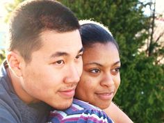 a man and woman are smiling for the camera with trees in the back ground behind them