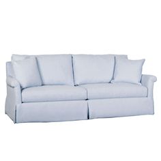 a white couch with blue pillows on the top and bottom cushions, in front of a white background