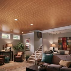 a living room with couches, chairs and stairs leading up to the second floor