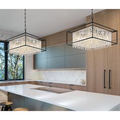 a kitchen with an island and chandelier hanging from the ceiling