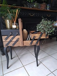 a plant sits on top of a wooden table in front of a black fireplace with potted plants