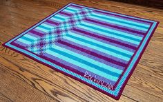 a blue and purple rug sitting on top of a wooden floor