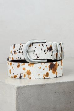 For the daring woman—unafraid to dazzle down to the smallest details—we present the Powell belt, crafted from South American cowhide leather. Its silky hair-on cowhide features a stylish splatter effect that catches the eye and complements your outfit. Finishing this bold design is a nickel-free rounded buckle and three keepers to keep you securely cinched. With smooth leather lining. Modern Calf Leather Belt With Buckle Closure, Cowhide Belt, Luxury Calf Leather Belt Buckles, Luxury Leather Concho Belt, Luxury Gold Western-style Belts, Promo Gifts, Sheepskin Slippers, Sheepskin Coat, Belt Style