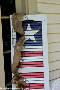 an old shutter is decorated with red, white and blue stripes for the fourth of july