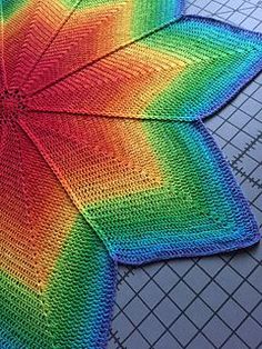 a colorful crocheted umbrella sitting on top of a table next to a cutting board