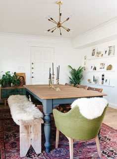 a dining room table with two chairs next to it and a rug on the floor