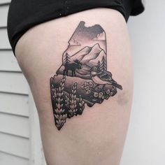 a woman's thigh with a black and white tattoo design on it, showing the outline of a mountain range