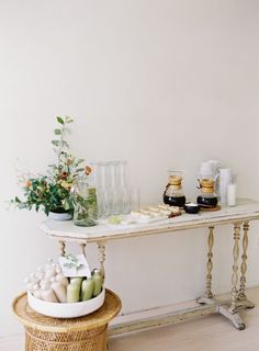 a white table topped with vases filled with flowers and other items on top of it