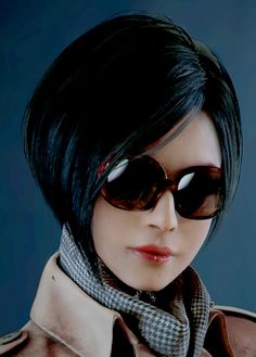 a woman with black hair wearing sunglasses and a scarf