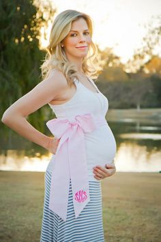 a pregnant woman wearing a pink and white dress