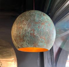 a large metal ball hanging from the ceiling next to a light fixture in a room