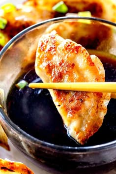 some food in a bowl with chopsticks sticking out of the meat and vegetables