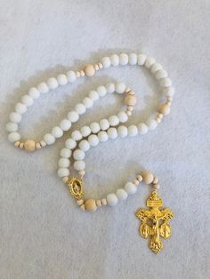 "This soft, beautiful rosary makes the perfect gift for any occasion. Carefully crafted with highest quality materials. The Hail Mary beads are made of 100% sheep's wool felt balls and the Our Father beads are natural wood. The high quality gold toned Crucifix and Centerpiece are absolutely beautifully detailed. This unique crucifix is called a Triple Threat Crucifix because it combines 3 of the most powerful sacramentals of the Church into one piece! There is an indulgence granted by Pope Saint Pius X each time you kiss this crucifix. Die cast for exceptional detail.  Hail Mary Wool Beads: 1 cm diameter Our Father Wood Beads: 12 mm diameter Small Wood Spacer Beads: 6 mm diameter Crucifix: 2 1/8\" Total Length when laid flat: approximately 18 inches" Beautiful Rosary, Bead Rosary, Felt Beads, Felt Balls, Hail Mary, Rosary Catholic, Rosary Beads, Triple Threat, Star Gift