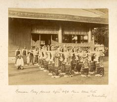 an old black and white photo of some people in front of a building with their arms around each other