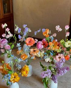 several vases filled with different colored flowers on a table