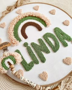 an embroidery project with the word love spelled out in green and brown