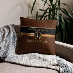 a pillow that has been placed on a couch in front of a potted plant