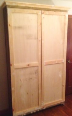 an unfinished armoire in the corner of a room