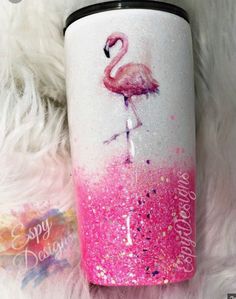 a pink and white flamingo painted on the side of a coffee cup with glitter