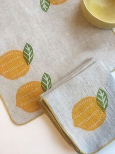 two placemats with yellow and green designs on them next to a small bowl