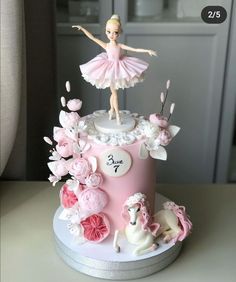 a pink cake with a ballerina figure on top