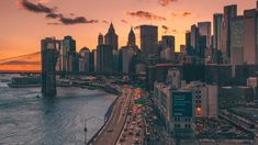 an aerial view of the city skyline at sunset, with cars driving on the road