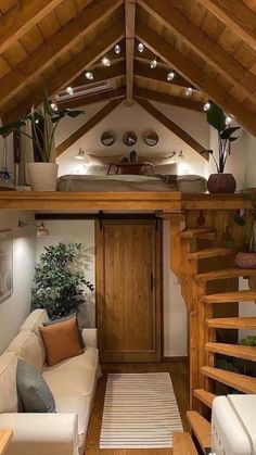 the inside of a tiny house with stairs leading up to the loft and living room