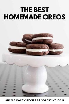 the best homemade oreos recipe on a white cake stand with chocolate cookies and cream filling