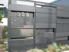 a black building with the number 350 on it's side and bushes in front