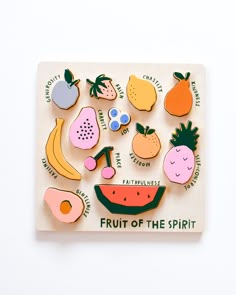 fruit of the spirit magnets on a wooden board with an illustration of different fruits and vegetables