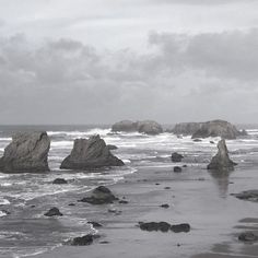 some rocks in the water on a cloudy day