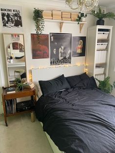 a bed sitting in a bedroom under a chandelier next to a shelf with pictures on it