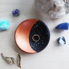 an assortment of stones and jewelry sitting on a table next to each other with one ring in the middle