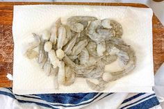 some kind of food on top of a white towel next to a wooden cutting board