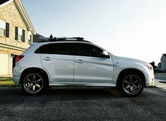 a white suv parked in front of a house