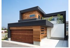 a modern house with wood siding and black roofing on the side of the building