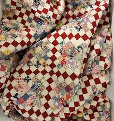 a red and white checkered quilt is laying on the floor