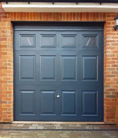 a blue garage door on a brick building