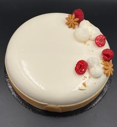 a cake with white frosting and raspberries on top