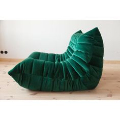 a green bean bag chair sitting on top of a wooden floor