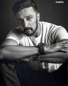 a man with a watch on his wrist posing for a photo in black and white