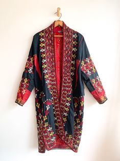 Fantastic traditional Turkmen robe/duster. Vivid colors and carefully embroidered workmanship. One of the best examples of this type of traditional wear we have come across. Infinitely wearable and looks great with jeans and boots. Add flair to a jeans and t uniform. Fabric: cotton/silk/ otherFit: S/MEra: 1940's Measurements: Bust 48" Sleeve (from collar) 32" Length 43" Waist 48" Hips 52" Condition: Excellent Red Folk Cotton Outerwear, Traditional Fitted Outerwear With Embroidered Border, Fitted Traditional Outerwear With Embroidered Border, Traditional Fitted Cotton Kaftan, Fitted Cotton Traditional Kaftan, Traditional Outerwear With Kimono Sleeves For Festivals, Traditional Festival Outerwear With Kimono Sleeves, Embroidered Kaftan For Fall Festival, Folk Style Multicolor Embroidered Long Sleeve Kimono