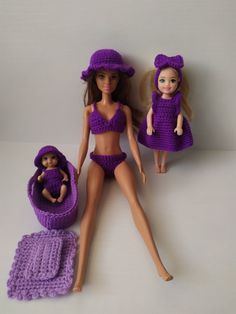 two dolls in bathing suits and one doll is laying on the ground next to a crocheted towel