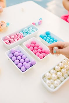 an instagram page with different colored candies in small bowls on the table, and someone placing them into their own cupcakes