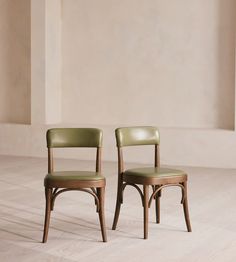 two chairs sitting side by side in an empty room